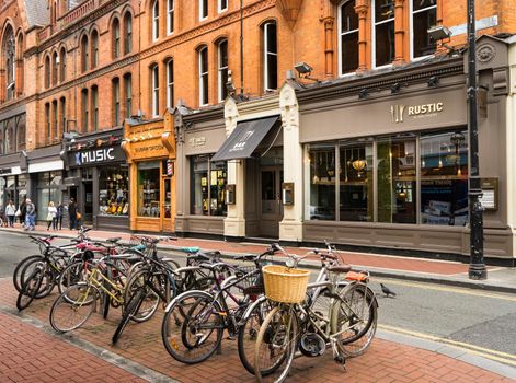 Shopping street in Dublin, with a group of bicycles in the foreground and a building with shops in the background.