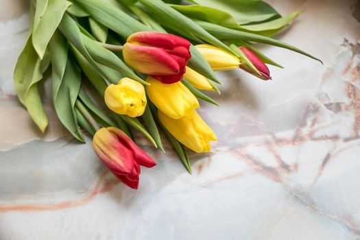 Beautiful tulips for Mother's Day on marble background, top view