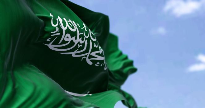 Detailed close up of the national flag of Saudi Arabia waving in the wind on a clear day. West Asian country. Selective focus.