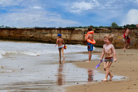 Two little boys are playing on the seashore. Children playing on the beach