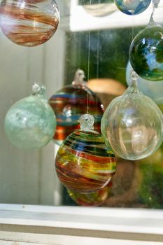 Multicolored glass balls in the window of a glass blowing workshop. Close up