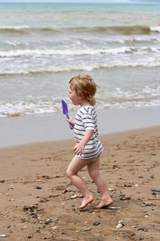 A little boy runs along the sandy beach along the seashore. Child resting on the sea