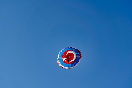 Parachute with the flag of turkey against the blue sky. Extreme vacation by the sea