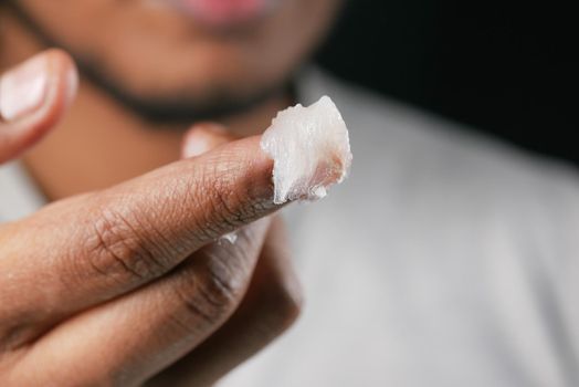 Close up of man hand using petroleum jelly .