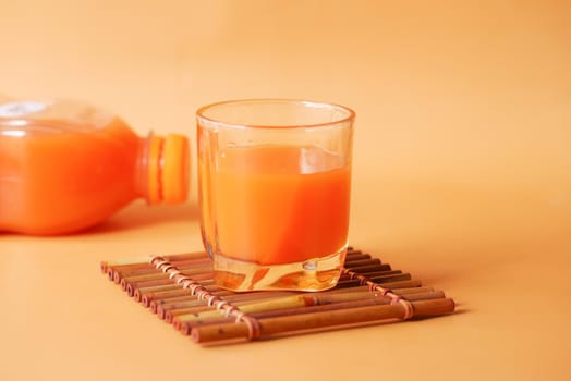 glass of orange juice and bottle on color color background ,