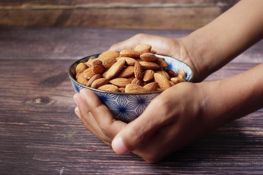 close up of almond nuts on man's hand .