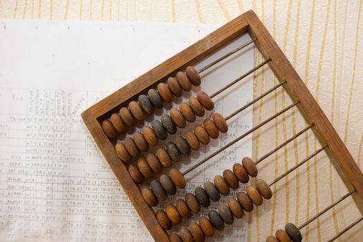 Old wooden abacus on the background of charts.