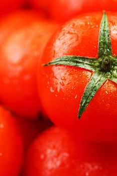 Fresh cherry tomatoes with closeup. Background red tomatoes. A group of juicy ripe fruits. red tomatoes background. Wallpaper tomato macro