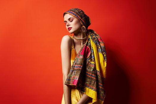 pretty woman multicolored shawl ethnicity african style red background. High quality photo