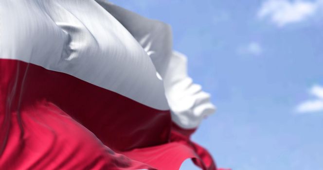 Detail of the national flag of Poland waving in the wind on a clear day. Democracy and politics. European country. Selective focus.