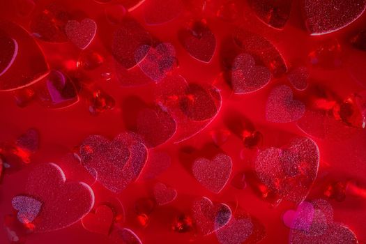 Valentine's Day Heart Abstract Multiple Exposure Background. Predominantly red image with hearts of different sizes, colors, and textures, including shiny, glittery, and gemstone. Lots of copy space.