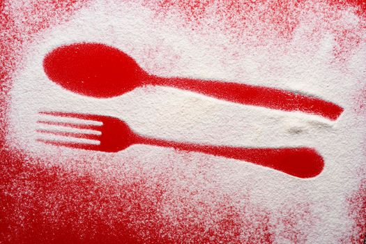 the imprint of the fork and spoon on a red colored surface