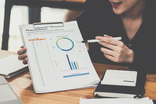 Business woman hand holding pencil and making presentation business strategy to her business team. Finance concept