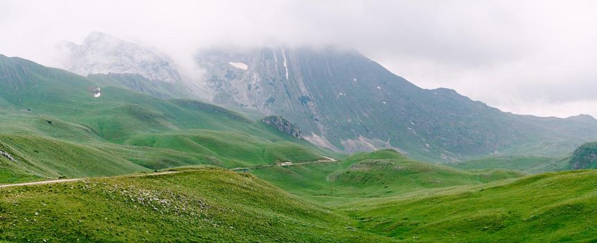 Mist descends from the mountains into a valley in Durmitor National Park. High quality photo