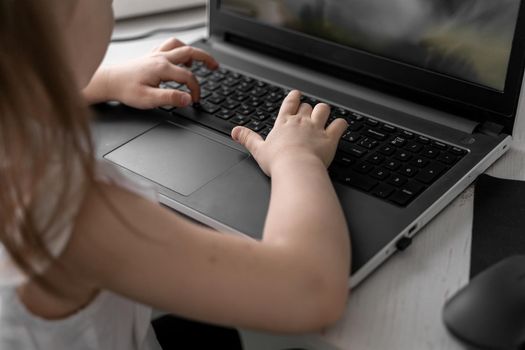 cute little caucasian girl studying online at home