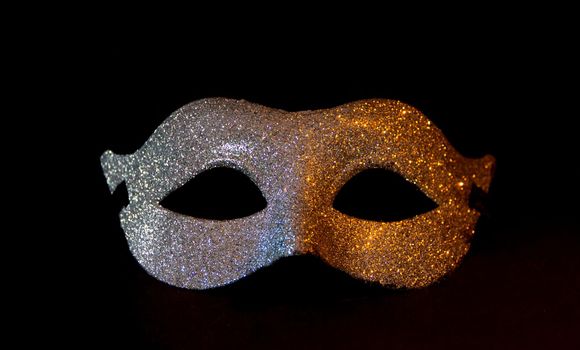 carnival symbol mask in silver color with glitter isolated on black background