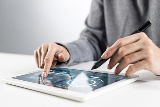 Woman using tablet computer for stock trading. Close-up of female hands touching screen of tablet device. Professional online investing and risk analyzing. Mobile smart device in business process