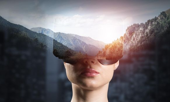 Young attractive woman in VR glasses. See nature through virtual reality