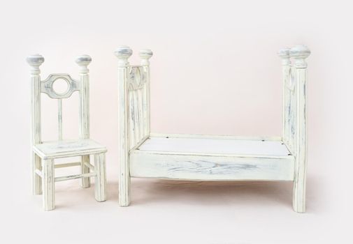 Rustic bed and chair furniture for newborn baby photoshoot. Old style interior sleeping place for infant child