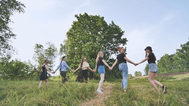 Schoolgirl friends are walking outside the city along a forest road