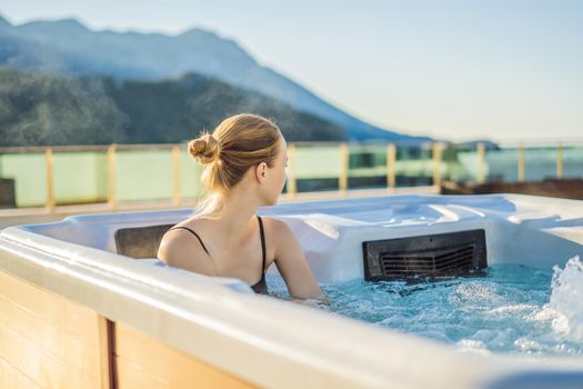 Portrait of young carefree happy smiling woman relaxing at hot tub during enjoying happy traveling moment vacation life against the background of green big mountains.