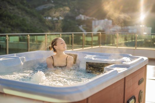 Portrait of young carefree happy smiling woman relaxing at hot tub during enjoying happy traveling moment vacation life against the background of green big mountains.