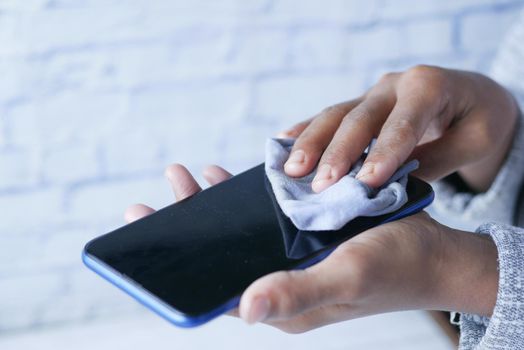 man hand cleaning mobile phone display