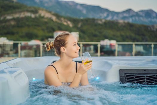 Portrait of young carefree happy smiling woman relaxing at hot tub during enjoying happy traveling moment vacation life against the background of green big mountains.