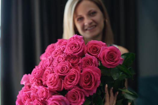 Portrait of attractive young female hold bouquet of pink flowers on birthday or anniversary. Pink roses present from relative. Attention, beauty concept