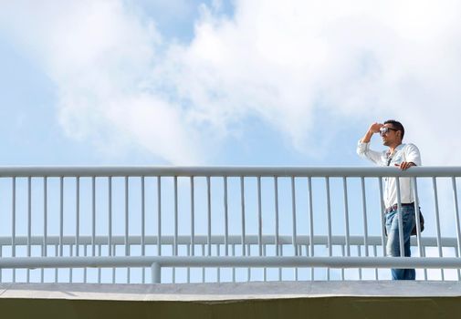 Young business man with sunglasses looking far away