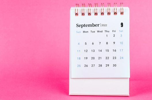 The September 2022 desk calendar on pink background.