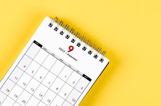 Close-up September 2022 desk calendar on yellow background.