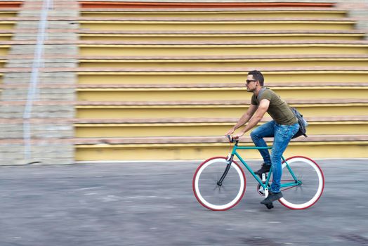 Male with sunglasses riding bicycle in urban city commuting trendy transportation