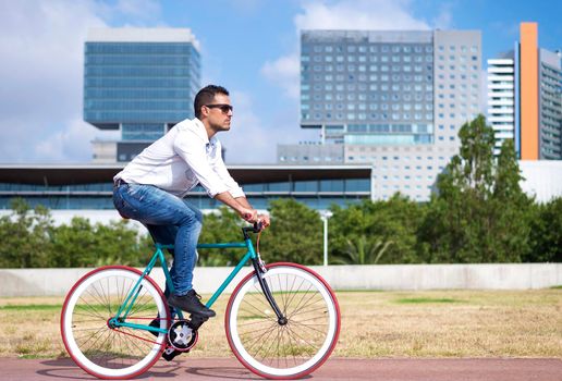 Male with sunglasses riding bicycle in urban city commuting trendy transportation