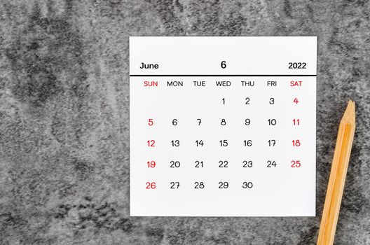 The June 2022 and wooden pencil on vintage dark background.