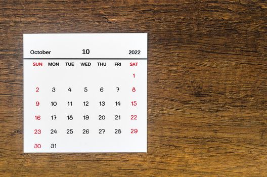 The October 2022 calendar on vintage wooden background.