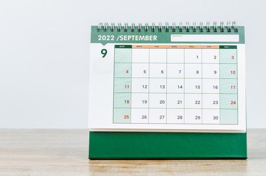 The September 2022 desk calendar on wooden table.