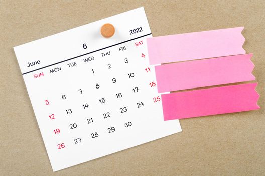 June 2022 calendar with blank adhesive note paper on brown background.