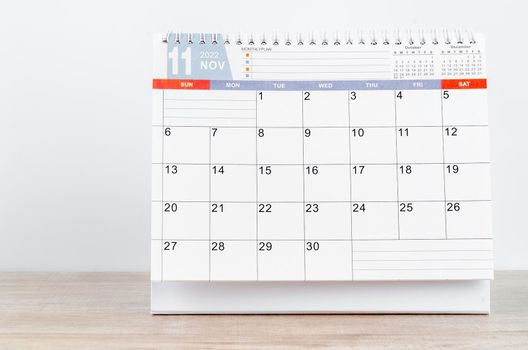 The November 2022 desk calendar on wooden table.