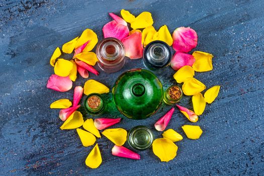 Bottles of essential oils surrounded by rose petals