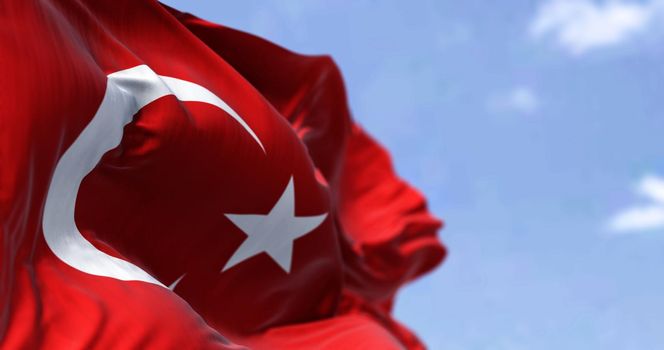 Detail of the national flag of Turkey waving in the wind on a clear day. Democracy and politics. Patriotism. Selective focus.