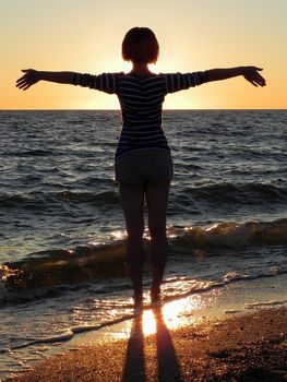 carefree woman dancing in the sunset on the beach. vacation vitality healthy living concept