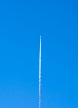 airplane contrail against clear blue sky with copy space