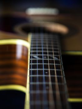 six - string acoustic guitar  on a black background. low key. music day