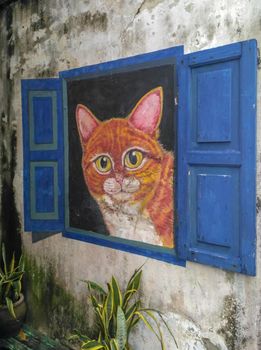 PENANG, MALAYSIA-2018-01-05: World famous street art with big cat inside open window wal