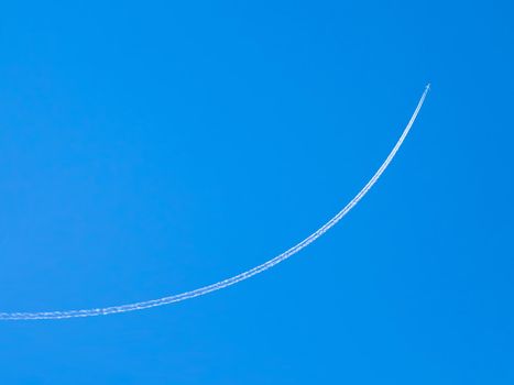 airplane contrail against clear blue sky with copy space