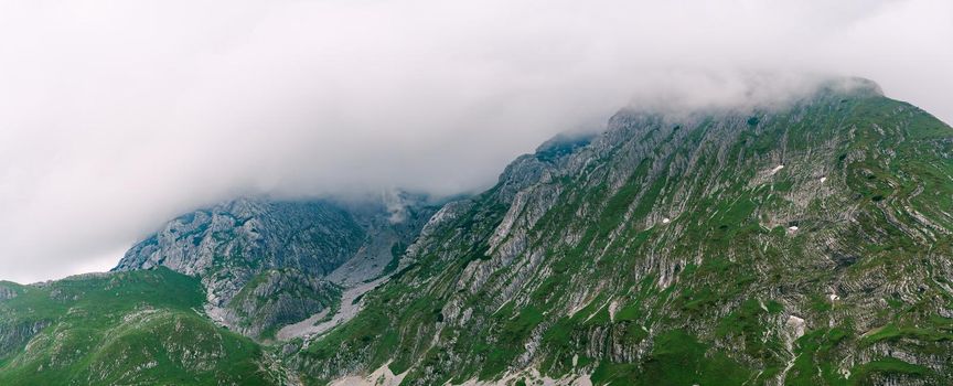 Thick fog envelops the mountain peaks of Durmitor National Park. High quality photo