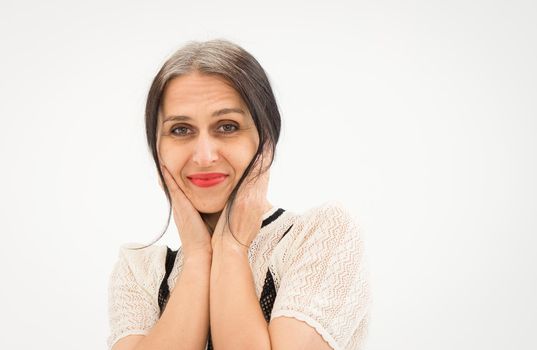 Studio photo of middle aged woman starting getting grey-haired wearing black and white clothes on white background, middle age sexy lady, happy life concept.