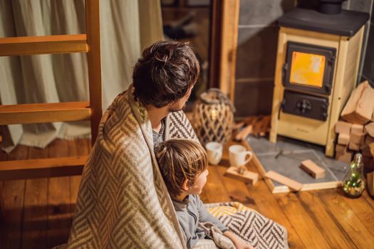 Dad and son spend time by the fireplace in Glamping. Rest in the mountains in Glamping. Cozy fireplace in a mountain house.