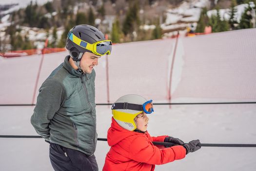 Instructor teaches boy skier to use on ski lift.